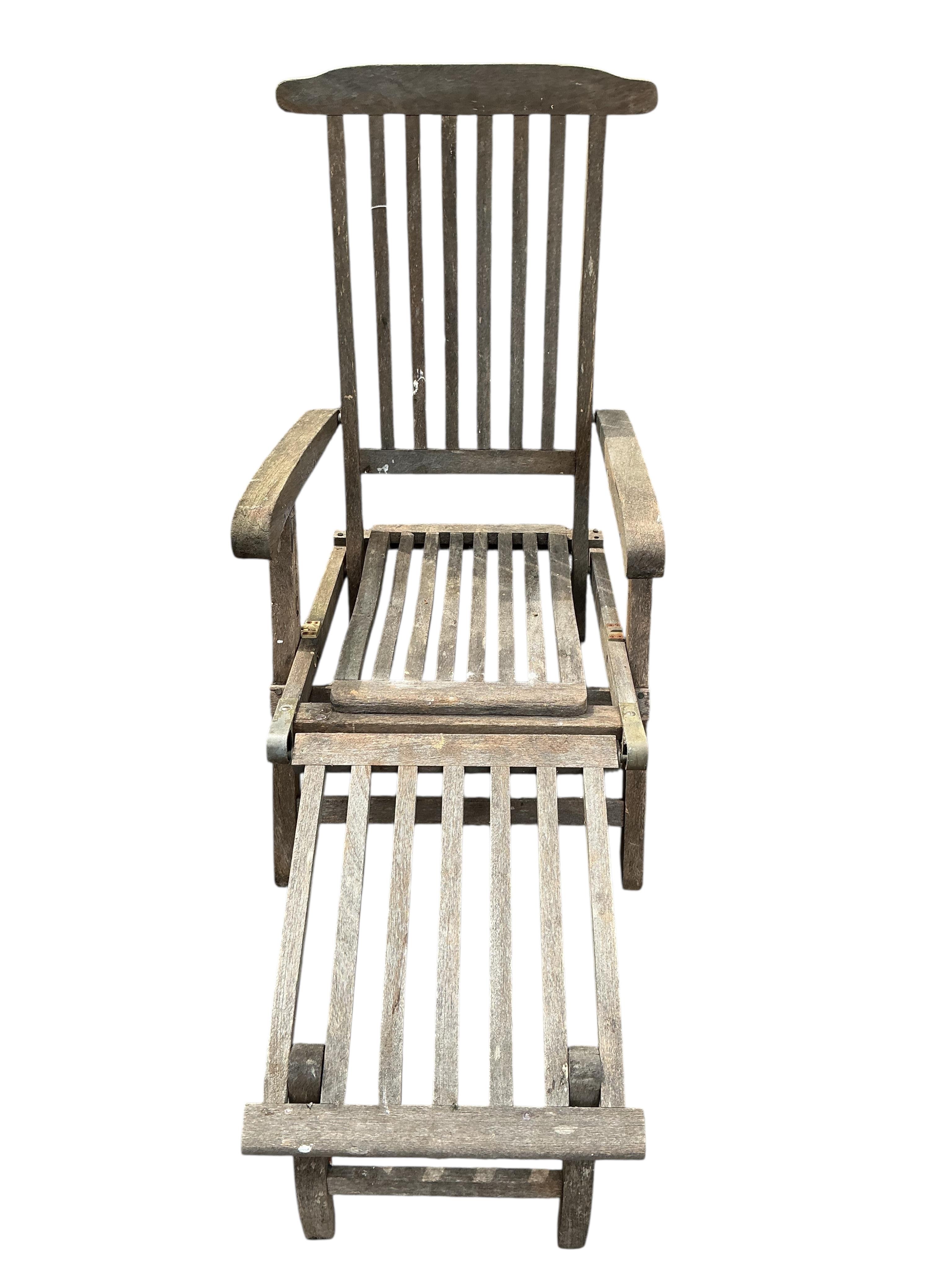 A pair of weathered teak garden steamer chairs